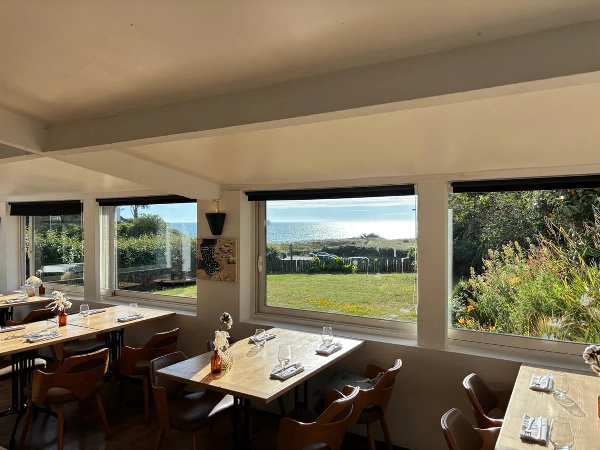 Salle lumineuse du restaurant Le Vert d'O avec vue sur la mer